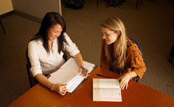 Decorative students reading paper at a desk