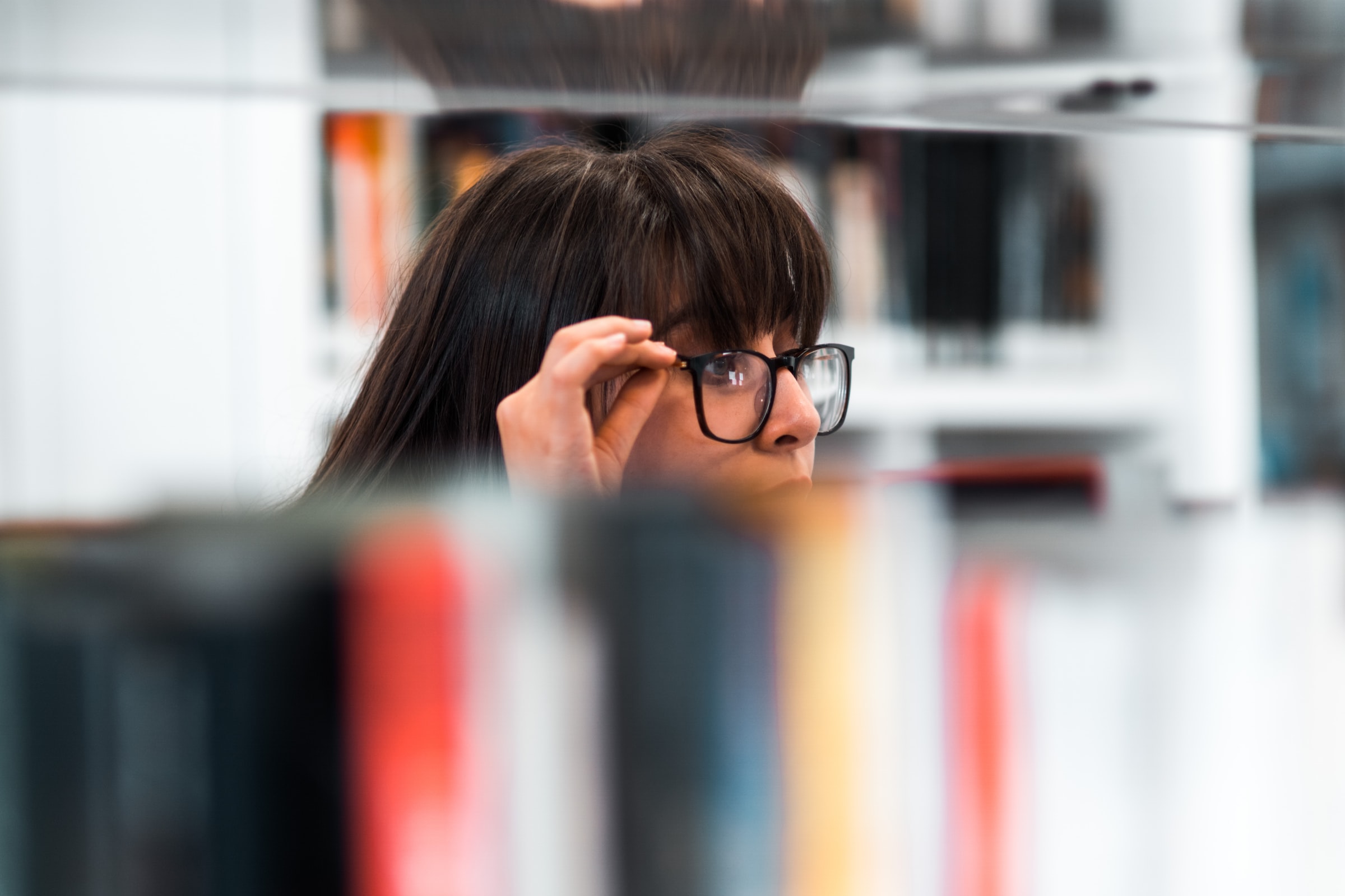 Decorative, person wearing glasses looking at books